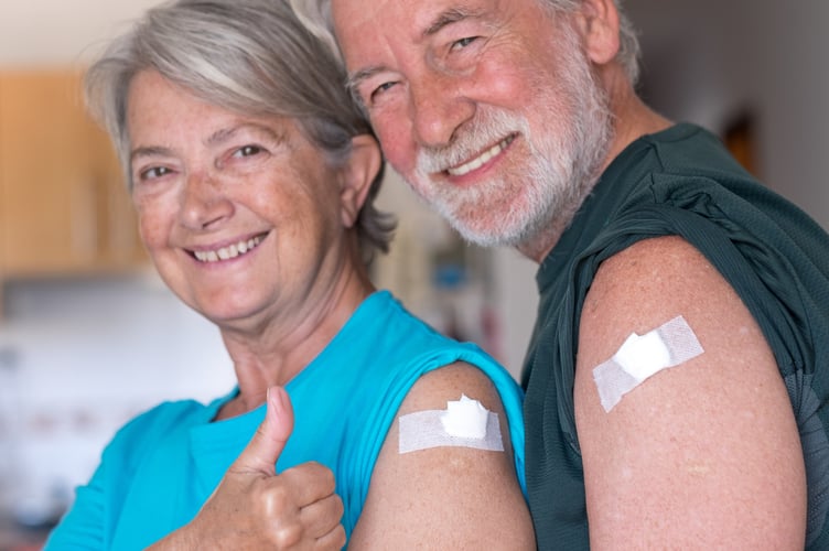 couple 70 years old smiling after receiving the booster of the coronavirus covid-19 vaccine. Concept of prevention and immunization