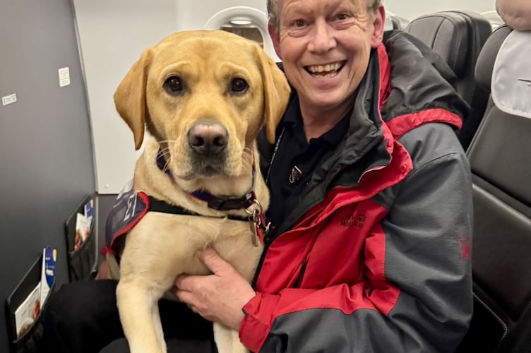 Hounds for Heroes founder Allen Parton and his assistance dog ET, aboard a British Airways Flight, their 80th one!